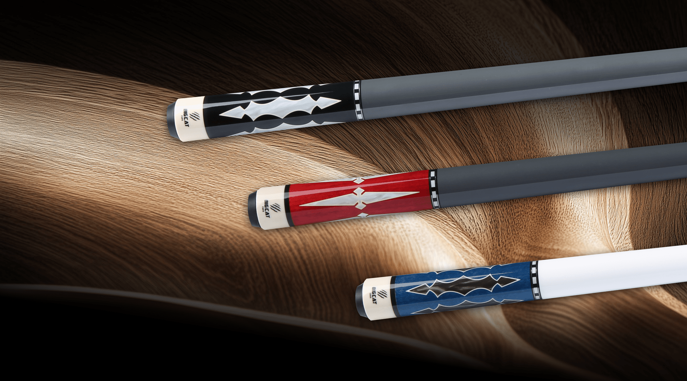 Three pool cues with decorative ends on a wooden surface