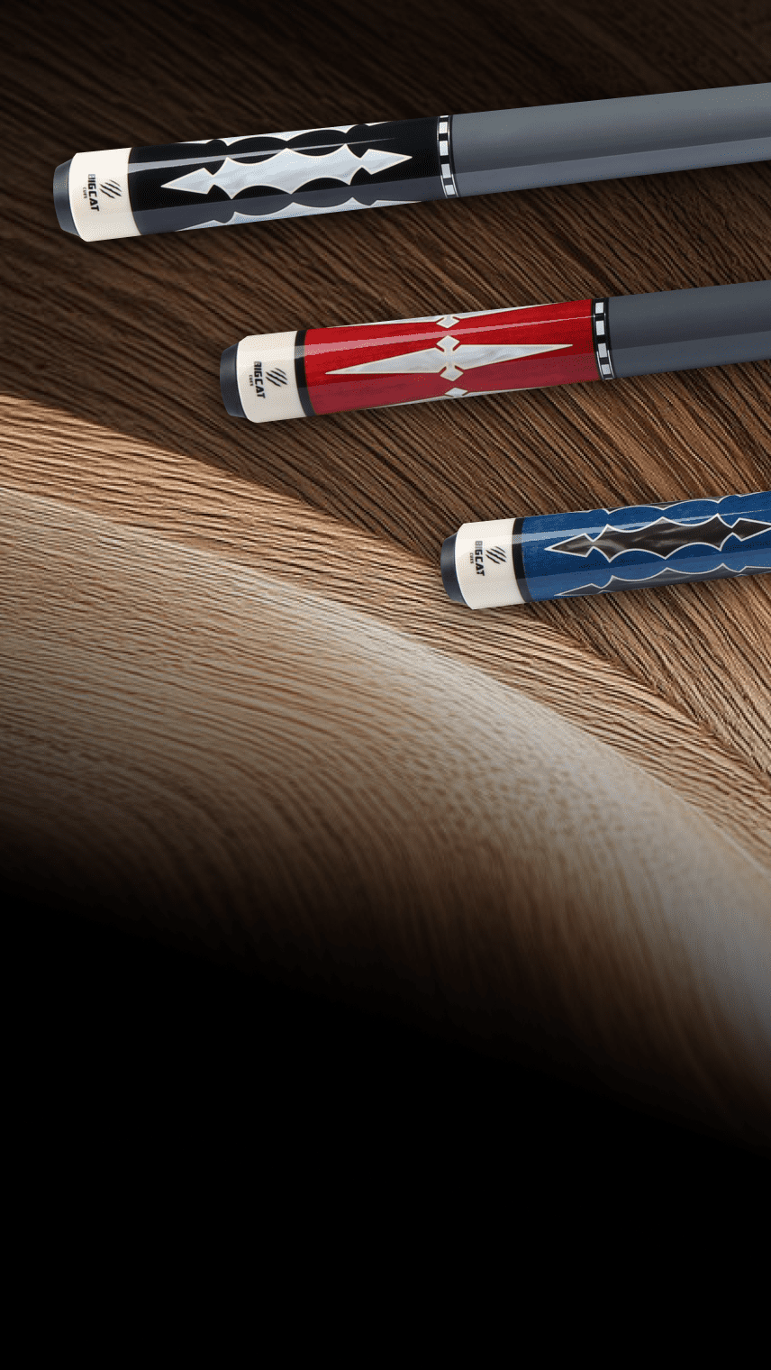 Three pool cues with different color handles on a wooden surface